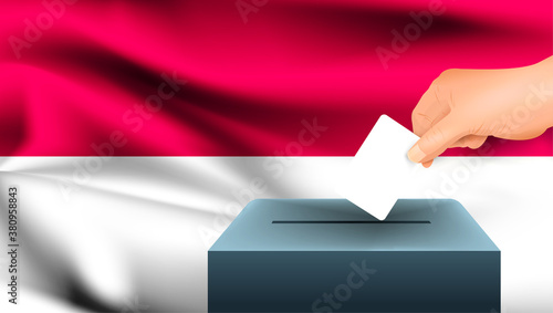 Male hand puts down a white sheet of paper with a mark as a symbol of a ballot paper against the background of the Indonesia flag. Indonesia the symbol of elections