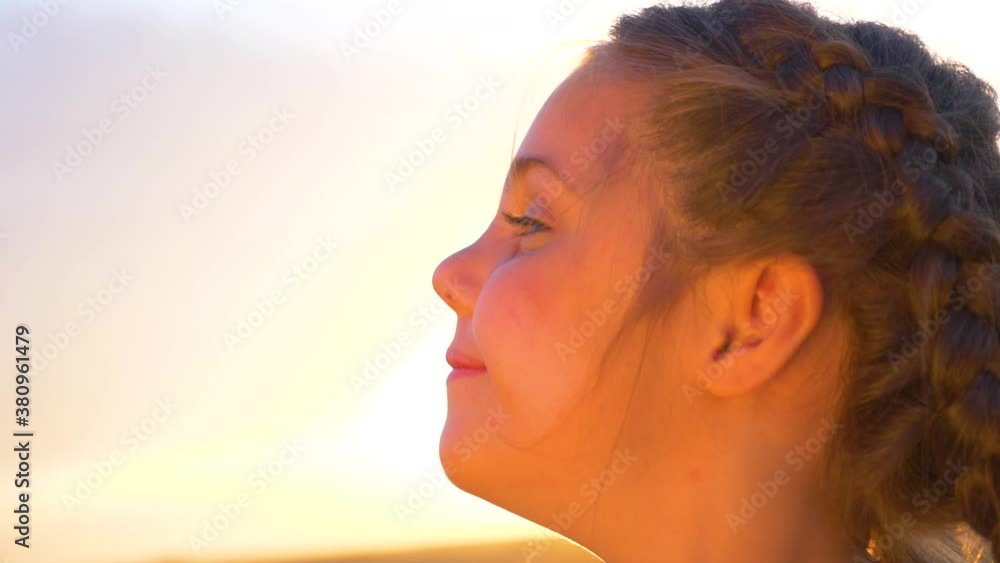 Beautiful portrait of a girl at sunset. A happy child enjoys fresh air, freedom. Children's meta. The concept of a happy family. Beautiful portrait of a girl at sunset. A happy child enjoys fresh air, freedom. Children's meta. The concept of a happy family.