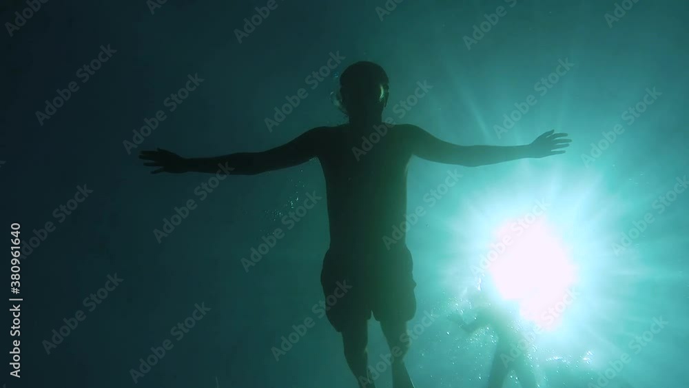 Boy placing a camera on the bottom of the sea. Boy placing a camera on the bottom of the sea.