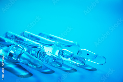 glass ampoules with liquid medicine in blue light