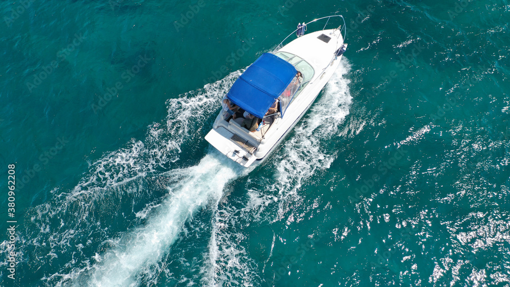 Fototapeta premium Aerial drone photo of luxury power boat cruising in deep blue sea near Mediterranean Aegean island