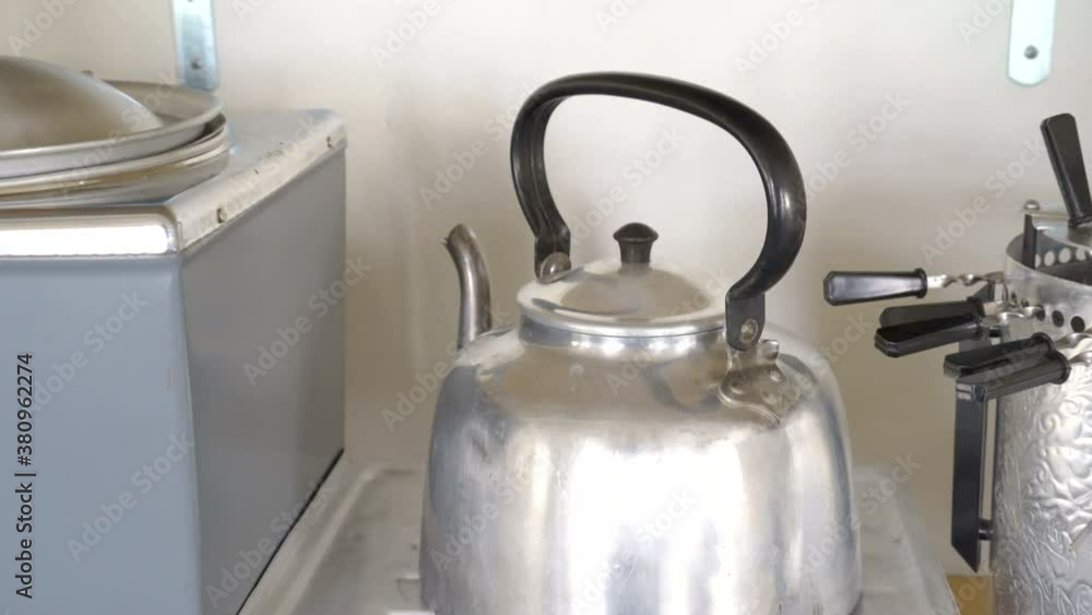 The silver kettle on the top of the stove The silver kettle on the top of the stove