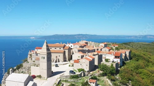 Amazing historical town of Lubenice on the high cliff, Cres island in Croatia, Adriatic sea in background, drone circle footage