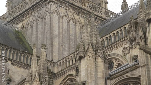 A slow tilt shot of the beautiful and ancient tower of Bayeux cathedral. Classic example of a French cathedral incorporating flying buttresses. photo