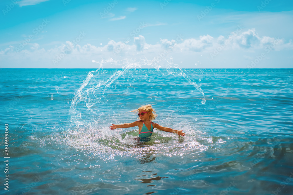 happy cute girl splash water on beach