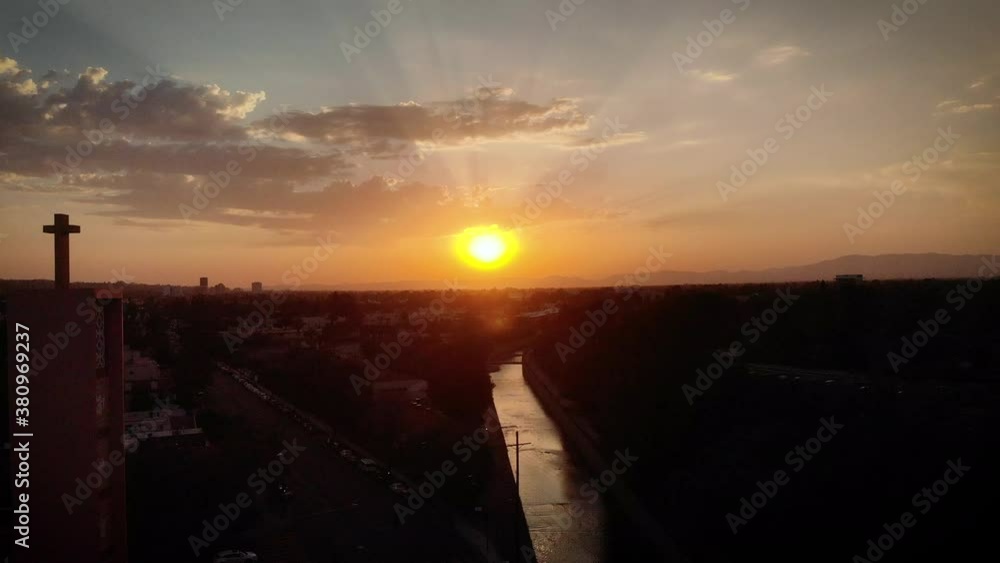 Aerial view of a beautiful sunset behind a silhouetted church tower. Aerial view of a beautiful sunset behind a silhouetted church tower.