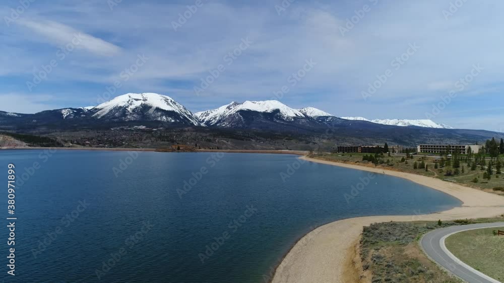 Dillon Lake, Dillon Colorado. Drone flyby going West following the shore line with snow capped mountains in the foreground. Dillon Lake, Dillon Colorado. Drone flyby going West following the shore line with snow capped mountains in the foreground.