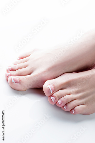 female feet barefoot, woman applying cream on her leg