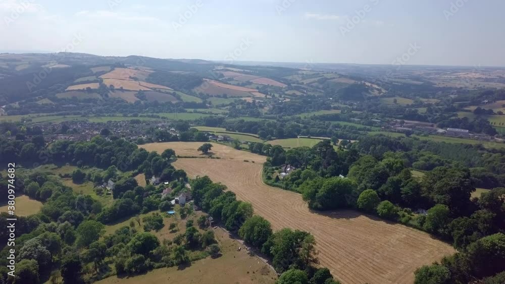 Soaring over a mowed yellow pasture in the patchwork English countryside Soaring over a mowed yellow pasture in the patchwork English countryside