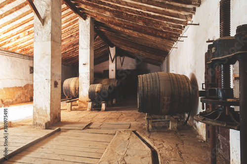 Foto Wine barrels stacked in the old cellar of the vinery in Spain