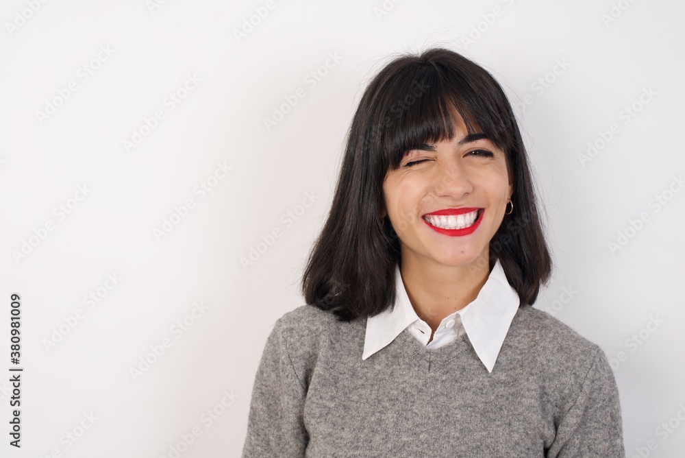 Coquettish Young businesswoman with retro short hair wearing casual clothes standing smiling happily, blinking at camera in a playful manner, flirting with you. Human facial expressions and emotions Coquettish Young businesswoman with retro short hair wearing casual clothes standing smiling happily, blinking at camera in a playful manner, flirting with you. Human facial expressions and emotions