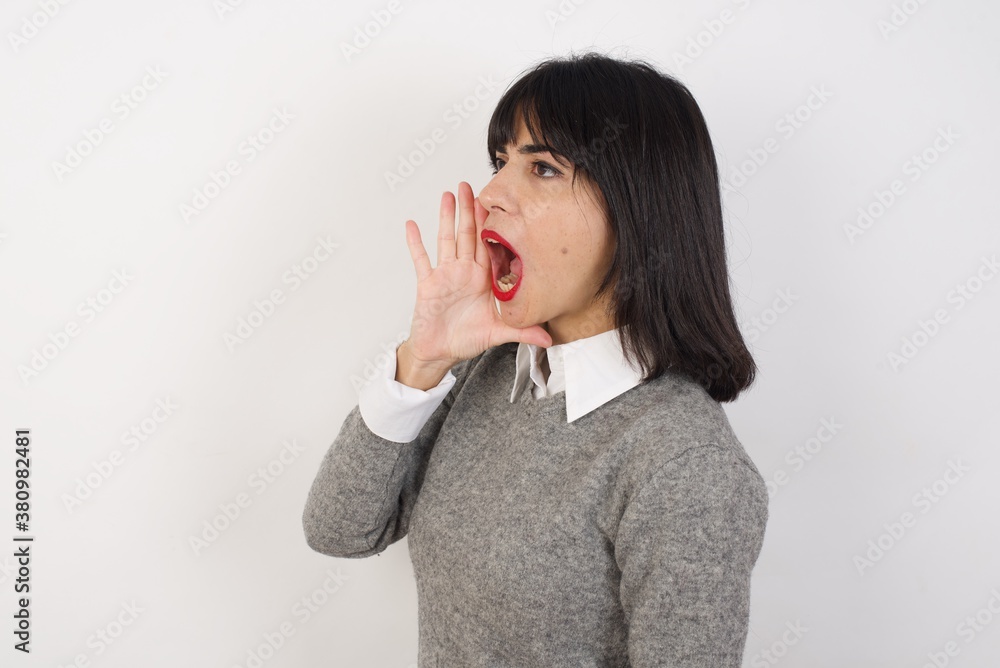 Young businesswoman with retro short hair wearing casual clothes standing over isolated white background shouting and screaming loud to side with hand on mouth. Communication concept. Young businesswoman with retro short hair wearing casual clothes standing over isolated white background shouting and screaming loud to side with hand on mouth. Communication concept.