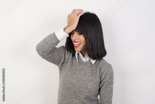 Young businesswoman with retro short hair wearing casual clothes standing over isolated white background surprised with hand on head for mistake, remember error. Forgot, bad memory concept.