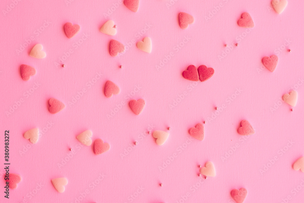 Candies hearts on pink and white paper. Flat lay for Valentine’s Day. Creative sweet concept. Background, top view