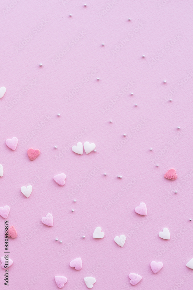 Candies hearts on pink and white paper. Flat lay for Valentine’s Day. Creative sweet concept. Background, top view