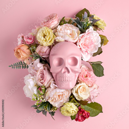 Fototapeta Naklejka Na Ścianę i Meble -  Creative Halloween layout made with pink skull surrounded by flowers on pink background. Minimal scary concept. Flat lay.