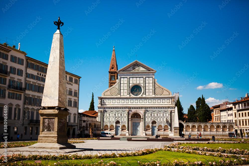 Close up. The facade of the white marble cathedral (the Santa Maria Novella Church) with the Romanesque-Gothic bell tower and sacristy in Florence, Tuscany, Italy. European architecture