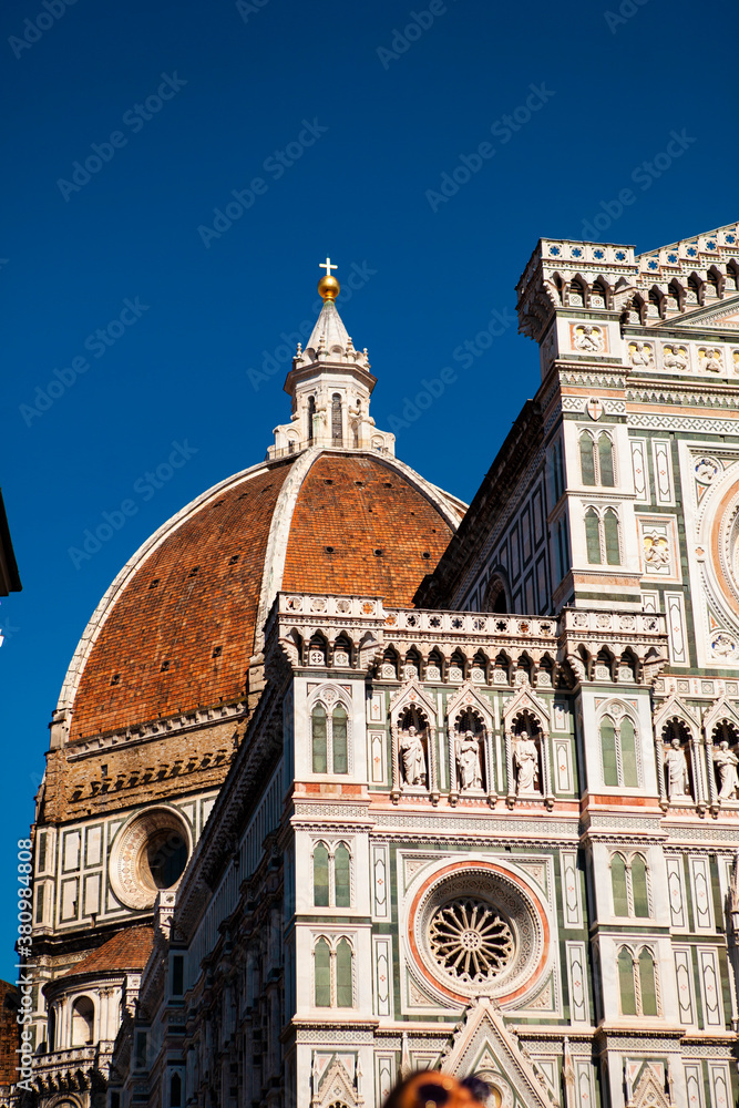 Close up. The white marble facade (exterior) of the central church (Duomo), also known as Santa Maria del Fiore Cathedral, with the tower and the Renaissance dome in Florence, Tuscany, Italy. Europe
