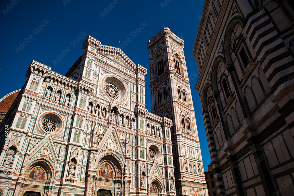 Close up. The white marble facade (exterior) of the central church (Duomo), also known as Santa Maria del Fiore Cathedral, with the tower and the Renaissance dome in Florence, Tuscany, Italy. Europe