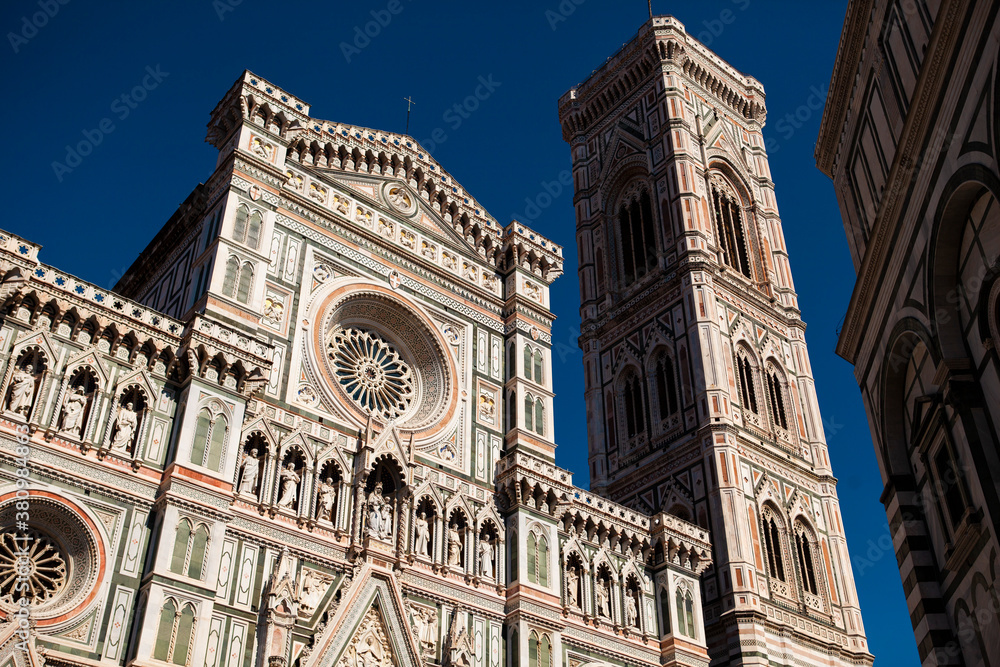 The white marble facade (exterior) of the central church (Duomo), also known as Santa Maria del Fiore Cathedral, with the tower and the Renaissance orange dome in Florence, Tuscany, Italy. Europe
