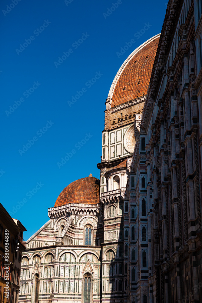 The white marble facade (exterior) of the central church (Duomo), also known as Santa Maria del Fiore Cathedral, with the tower and the Renaissance orange dome in Florence, Tuscany, Italy. Europe