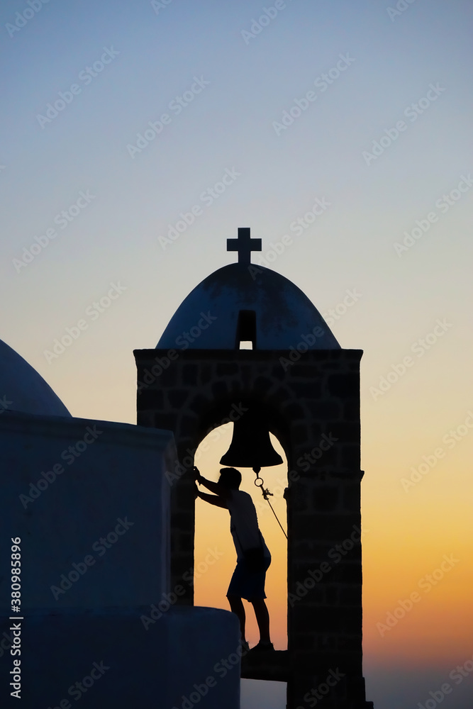 Man in bell tower silhouetted at sunset