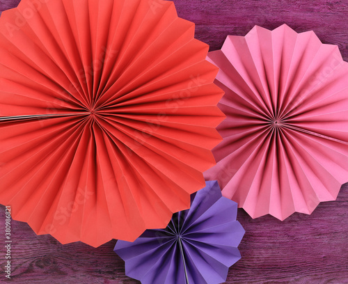 decorative colored paper fans  paper flowers isolated on red background