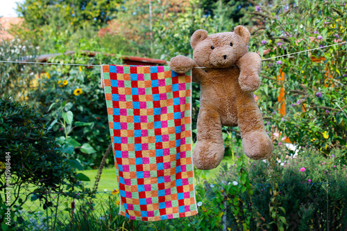Ein Teddybär hängt auf der Leine im Garten