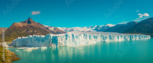 Panoramic view over gigantic Perito Moreno glacier in Patagonia with blue sky and turquoise water glacial lagoon, South America, Argentina, at sunny day..