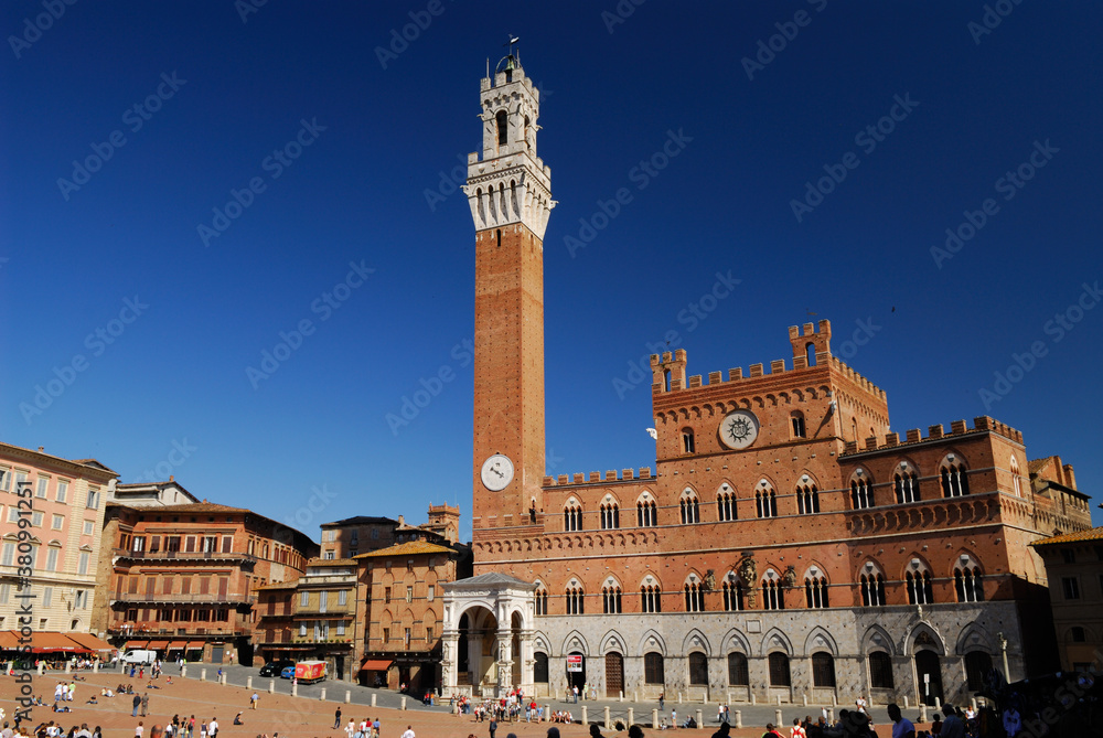 Red brick of the Palazzo Pubblico in Siena against a clear blue sky