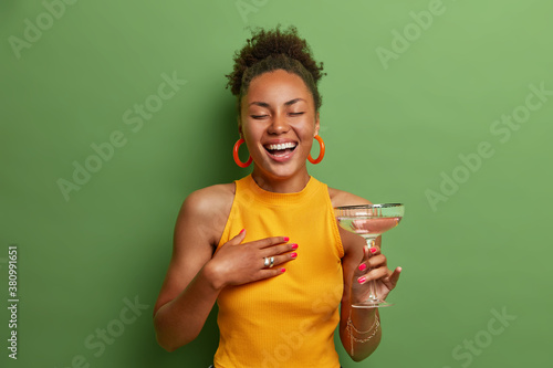 Photography Overjoyed dark skinned woman laughs happily keeps eyes closed and smiles broadly