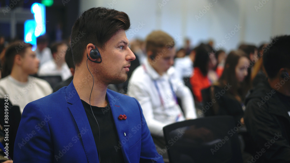 Audience business meet crowded forum person. Viewer conference listen headphone speaker auditorium. Event economic summit business man spectator. Group people listening translate speech crowd audience