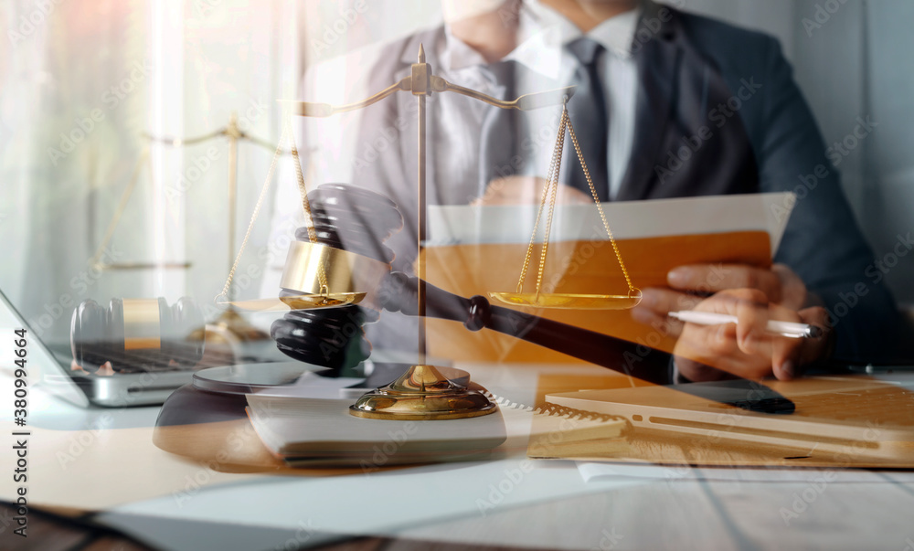 Business and lawyers discussing contract papers with brass scale on desk in office. Law, legal services, advice, justice and law concept picture with film grain effect Business and lawyers discussing contract papers with brass scale on desk in office. Law, legal services, advice, justice and law concept picture with film grain effect
