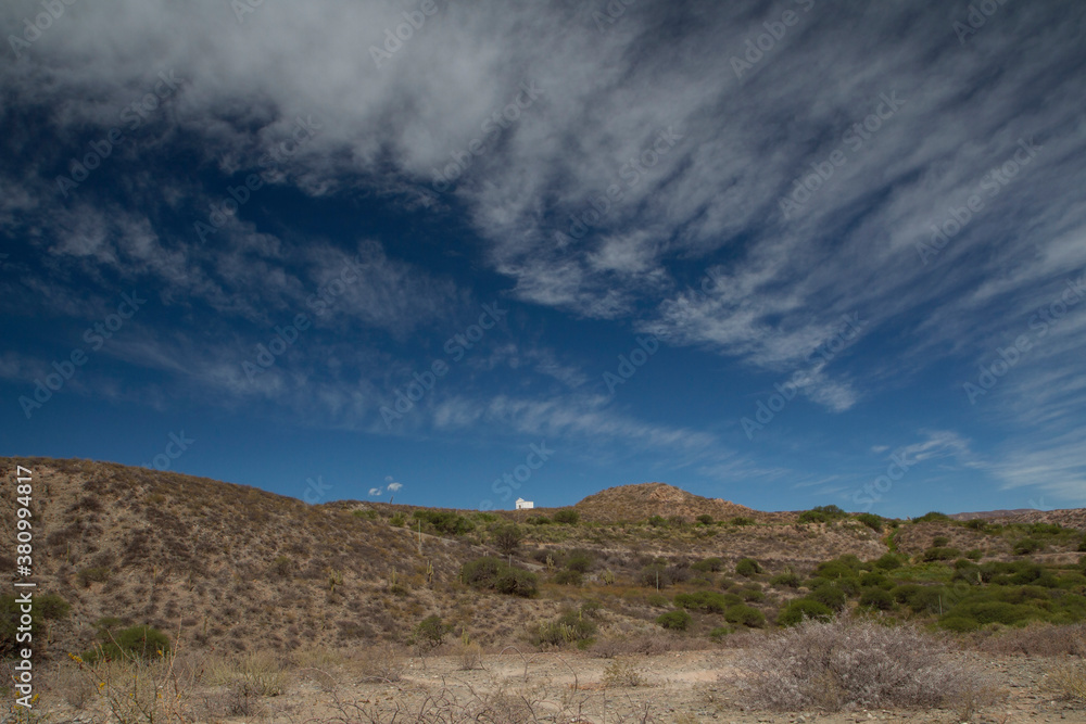 Allegoric view of a small chapel in the mountaintop under a beautiful deep blue sky with clouds. Allegoric view of a small chapel in the mountaintop under a beautiful deep blue sky with clouds.