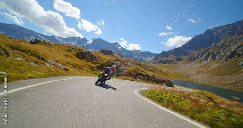 Extreme vacation concept, moto biker on a motorcycle rides a mountain road, tourist on the lake and hills in italy, freedom and enjoyment of life photo