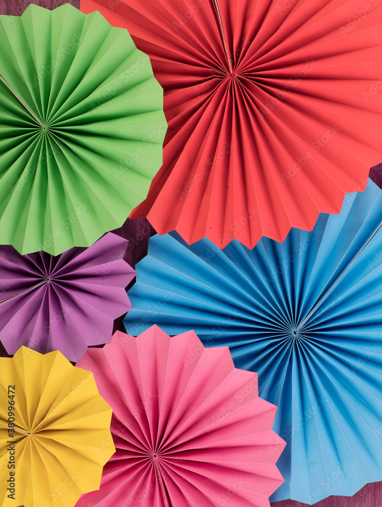 decorative colored paper fans, paper flowers isolated on red background