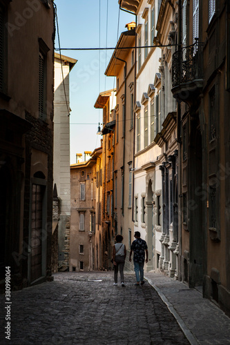 Bergamo, Lombardy / Italy - September 01, 2020 - Close up street view. Classic Italian lane in the middle of the city center with columns, vintage sculptures and statues. European architecture.