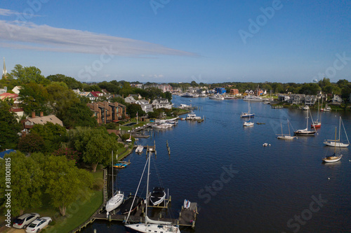 Aerial view of colorful sailboat moorings and docks surrounded by colorful residential rooftops on and azure blue Spa Creek, in historic downtown Annapolis Maryland on a sunny summer day