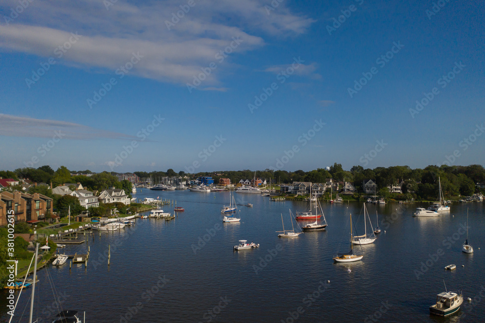 Aerial view of colorful sailboat moorings and docks surrounded by colorful residential rooftops on and azure blue Spa Creek, in historic downtown Annapolis Maryland on a sunny summer day