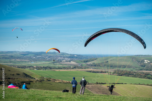 Paragliders take off from the South Downs in Sussex