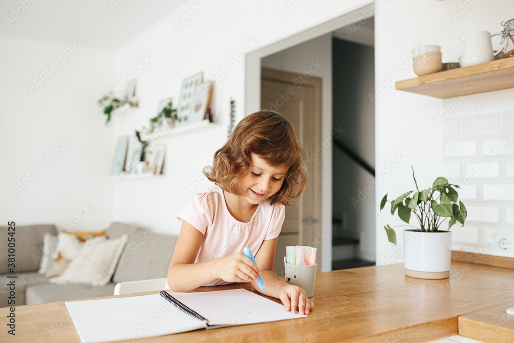 Cute happy little girl, adorable preschooler, 5 years child painting at the table in a white living room at home. Cute happy little girl, adorable preschooler, 5 years child painting at the table in a white living room at home.