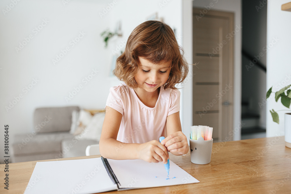 Cute happy little girl, adorable preschooler, 5 years child painting at the table in a white living room at home. Cute happy little girl, adorable preschooler, 5 years child painting at the table in a white living room at home.
