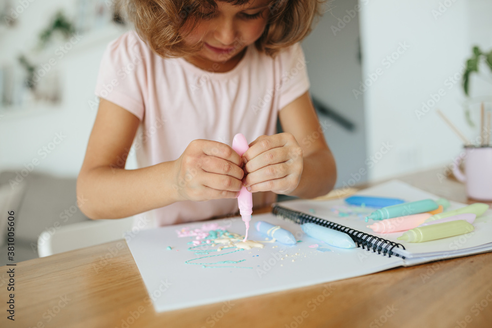 Cute happy little girl, adorable preschooler, 5 years child painting at the table in a white living room at home. Cute happy little girl, adorable preschooler, 5 years child painting at the table in a white living room at home.