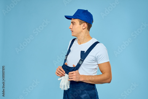 Working man in uniform of gloves loader rendering service blue background