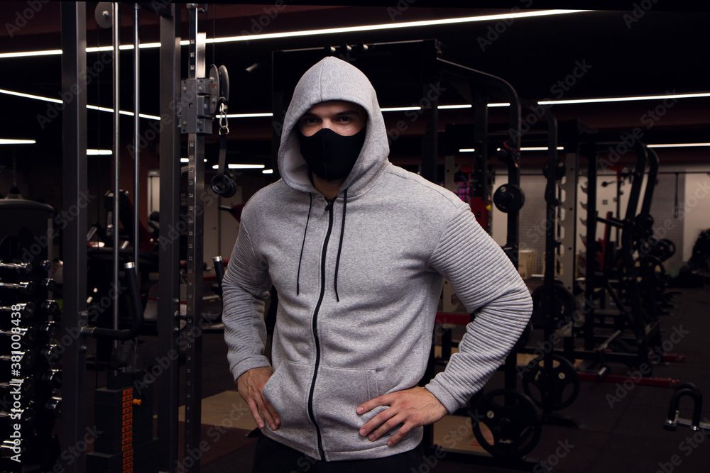Young athletic man wearing protective face mask while having sports  training in a gym during coronavirus Stock Photo | Adobe Stock