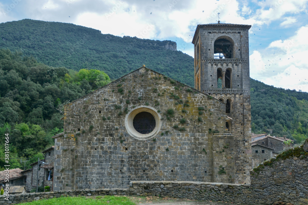 BEGET, CATALONIA, SPAIN, EUROPE, SEPTEMBER 2020. Fantastic Romanesque church of Saint Christopher or San Cristóbal, surrounded by stone houses in the beautiful medieval town of Beget