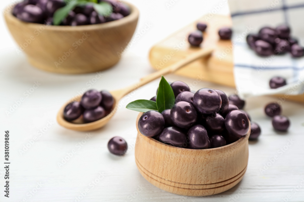 Tasty acai berries in bowl on white wooden table, closeup Tasty acai berries in bowl on white wooden table, closeup