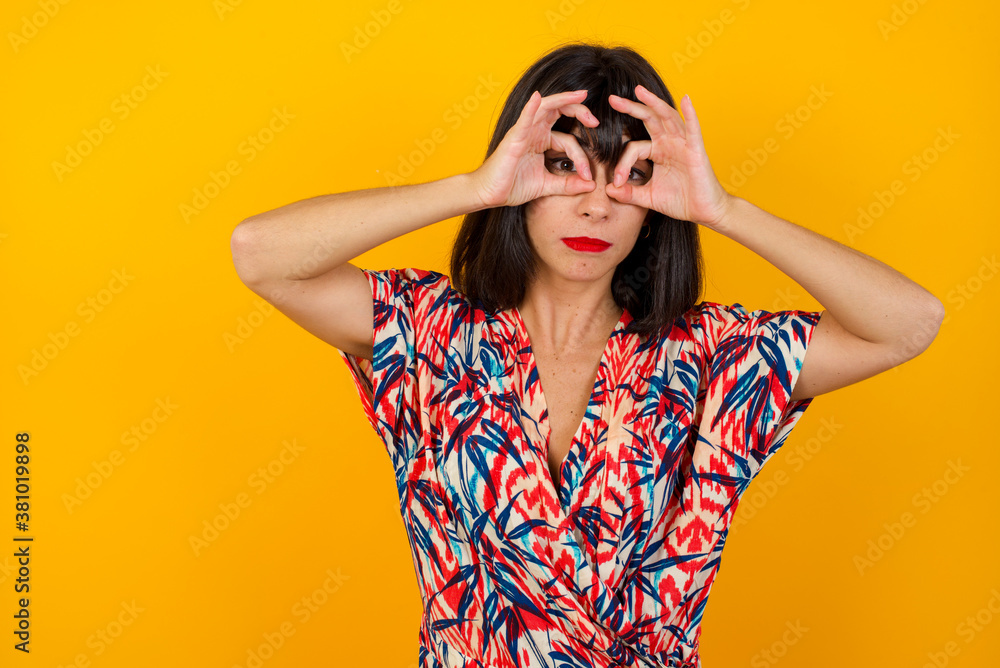 Playful excited teenage female with dark long hair showing Ok gestures with both hands, pretending to wear spectacles, astonished to see something amazing. Emotions, body language and gestures� Playful excited teenage female with dark long hair showing Ok gestures with both hands, pretending to wear spectacles, astonished to see something amazing. Emotions, body language and gestures�
