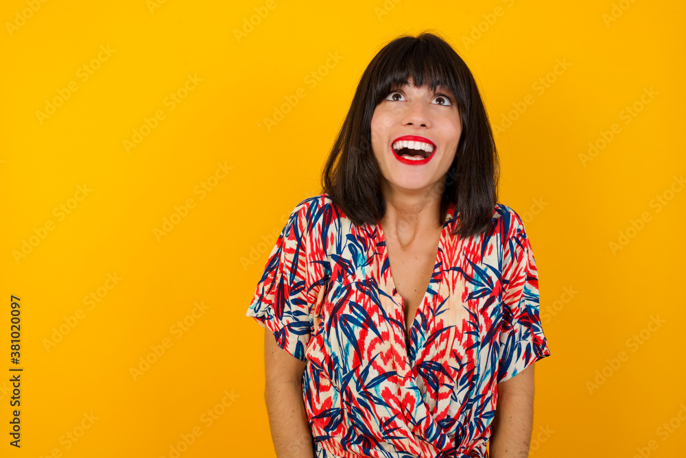 People and sudden reaction concept. Surprised caucasian beautiful female student, shrugs shoulders, looking sideways, being happy and excited about new plans with friends. Isolated over gray wall. People and sudden reaction concept. Surprised caucasian beautiful female student, shrugs shoulders, looking sideways, being happy and excited about new plans with friends. Isolated over gray wall.