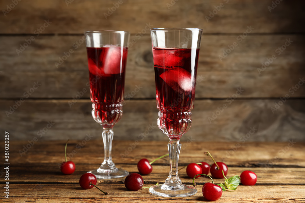 Delicious cherry wine with ripe juicy berries on wooden table Delicious cherry wine with ripe juicy berries on wooden table